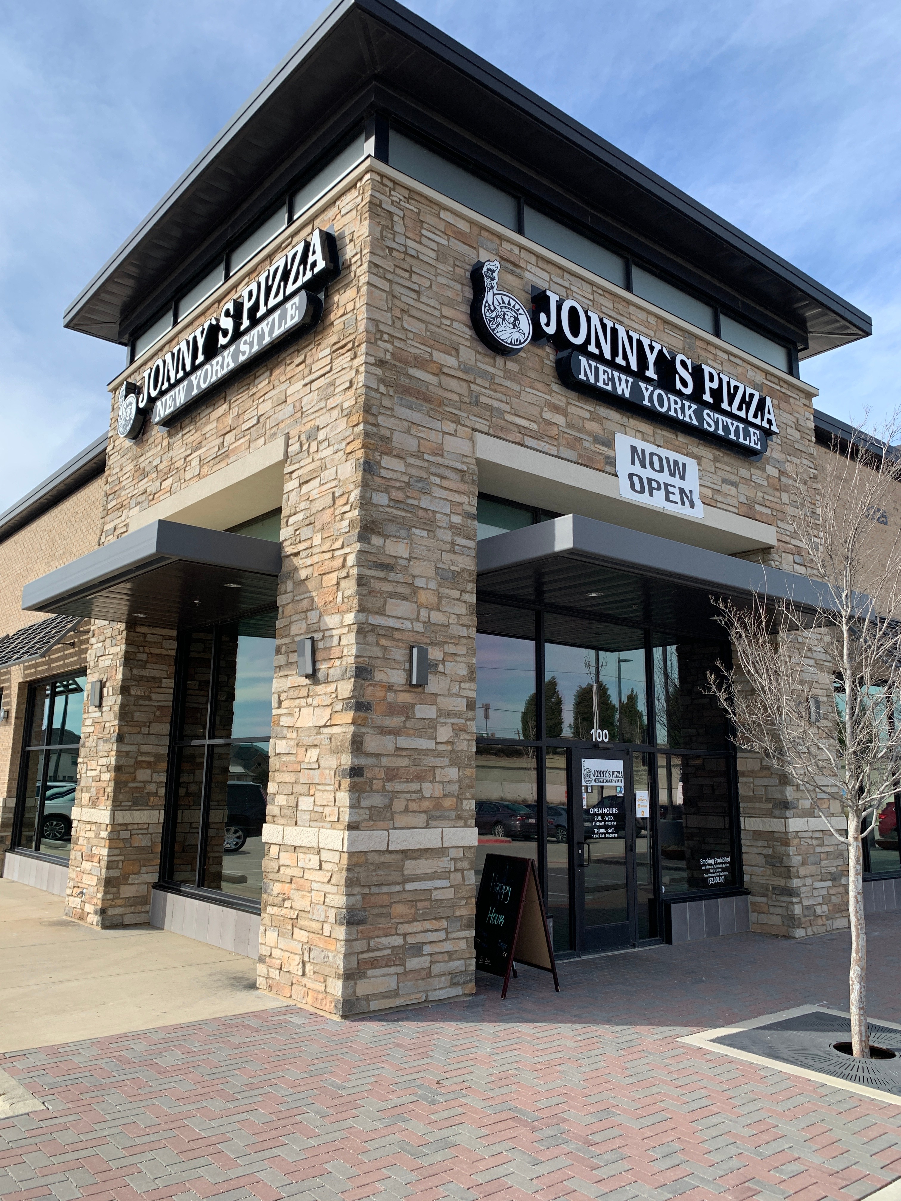 Storefront and pizza at Jonny's Pizza in Frisco, Texas